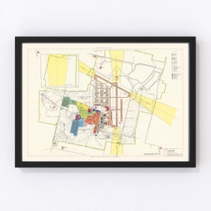 May include: A vintage map of a military base with a detailed layout of buildings and roads. The map is printed in black, white, and various colors, including red, green, yellow, and blue. The map is titled "RESTRICTED" and includes a legend with symbols and abbreviations.