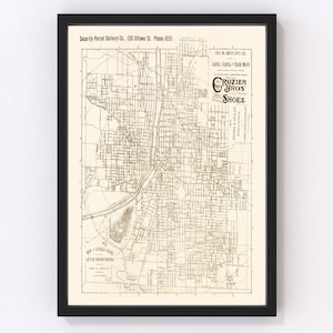 May include: A vintage map of Grand Rapids, Michigan, with a brown and white color scheme. The map shows the city's streets and landmarks, including the Grand River. The map is framed in a black frame. The map includes an advertisement for Rozier Bros. Foot Form Shoes.
