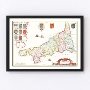 May include: Framed vintage map of Cornwall, England, featuring detailed cartography with colorful regions and historical illustrations. The map includes coats of arms, ships, and the Latin title "Cornubia Cornwallia."