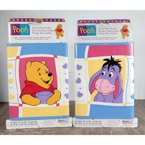 May include: Two rolls of decorative border featuring Winnie the Pooh and Eeyore. The borders have a colorful design with Pooh holding a pot and Eeyore smiling. Each roll is 8.5 sq. ft. (5 yd. x 6.83 in.).