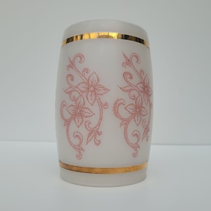 May include: A white frosted glass vase with a gold rim and pink floral design.