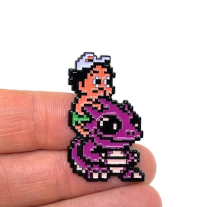 NES 用アドベンチャー アイランド、恐竜の相棒に乗るマスター ヒギンズ、マグマのエナメル ピンとマグネット - NES レトロ ゲーム アート - レトロ ゲーマー エナメル ピン