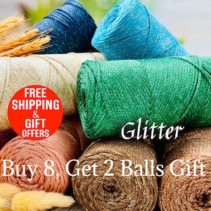 May include: A collection of colorful glitter yarn skeins in shades of blue, green, gold, and brown. The word "Glitter" is displayed in white script. The image also includes text that reads "Buy 8, Get 2 Balls Gift".
