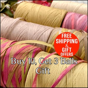 May include: Close-up of several spools of raffia ribbon in various colors, including beige, pink, and yellow. The spools are tightly wound and arranged in a row. The image includes text that reads "Buy 10, Get 3 Balls Gift".