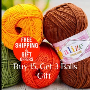 May include: Four skeins of Alize Cotton Gold yarn in yellow, brown, olive green, and orange. The brown skein features a white and pink label with the text 'cotton club alize Cotton Gold'. A red circular graphic overlays the yarn with text.