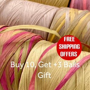 May include: Multiple spools of raffia ribbon in various shades of pink, yellow, and beige. The text on the image reads: FREE SHIPPING OFFERS, Buy 10, Get +3 Balls Gift. The ribbon is wound into cylindrical shapes with a flat, textured appearance.