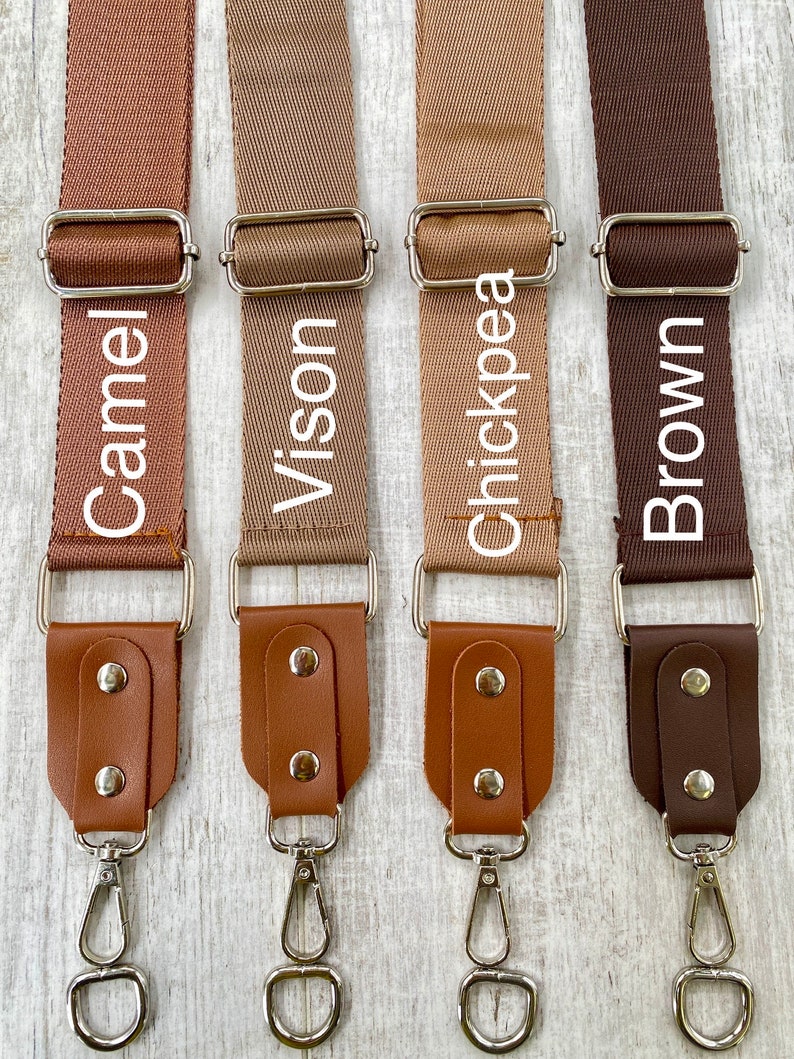 May include: Four adjustable bag straps in shades of Camel, Vison, Chickpea, and Brown. Each strap features a woven fabric section, a silver metal slider, and a leather-like end piece secured with two silver rivets and a silver swivel lobster clasp.