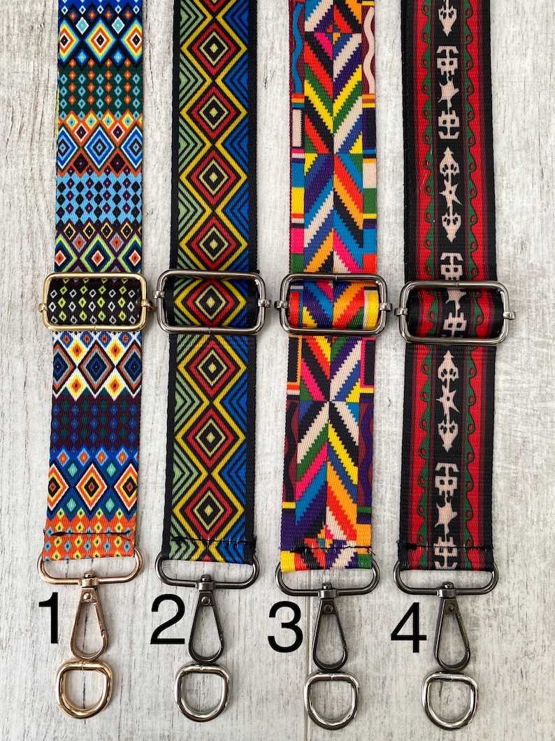May include: Four adjustable bag straps with metal hardware and lobster clasps. Strap 1 features blue and orange diamonds. Strap 2 has yellow and blue geometric patterns. Strap 3 displays a colorful chevron design. Strap 4 shows red and black motifs.