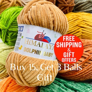 May include: A ball of tan chenille yarn with a white paper label featuring the text Himalaya Dolphin Baby, a red and blue yarn graphic, and a yellow duck icon, surrounded by other balls of yarn in various colors including green, orange, and yellow.