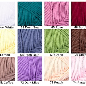 May include: A collection of yarn skeins in various colors, including white, teal, pink, and burgundy. Each skein is labeled with a number and color name, such as "62 Snow White" and "63 Deep Sea". The yarn appears soft and suitable for knitting or crochet projects.