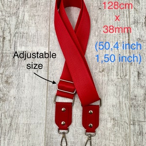 May include: A red adjustable bag strap with silver-tone metal hardware and swivel clasps. The strap features a total size of 128cm x 38mm (50.4 inches x 1.50 inches). The text on the image reads: Total size: 128cm x 38mm (50.4 inch 1.50 inch) Adjustable size.