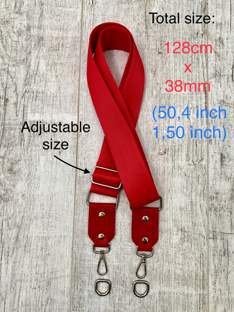 May include: A red adjustable bag strap with silver-tone metal hardware and swivel clasps. The strap features a total size of 128cm x 38mm (50.4 inches x 1.50 inches). The text on the image reads: Total size: 128cm x 38mm (50.4 inch 1.50 inch) Adjustable size.