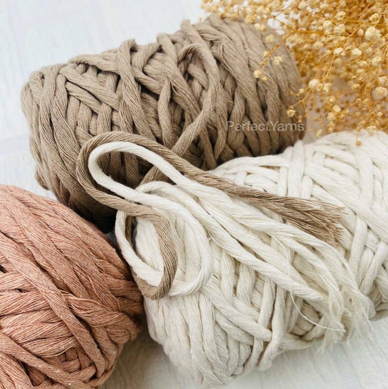 Pu&ograve; includere: Tre matasse di corda di cotone intrecciato spesso nei toni del beige, crema e rosa antico. Il filato presenta una consistenza morbida e tessuta con una struttura intrecciata visibile. Il testo PerfectYarns &egrave; stampato in piccole lettere scure sul cordino beige.