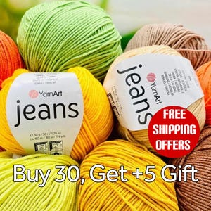 May include: A collection of YarnArt Jeans yarn balls in various colors including lime green, bright yellow, orange, and beige. Each ball features a white paper label with the text YarnArt jeans, 50g, 1.76 oz, and 160m, 174 yds printed on it.