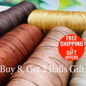 May include: Close-up of several spools of colorful cord in shades of brown, gold, and tan. The cord is tightly wound and has a textured appearance. The image includes text that reads "Buy 8, Get 2 Balls Gift".