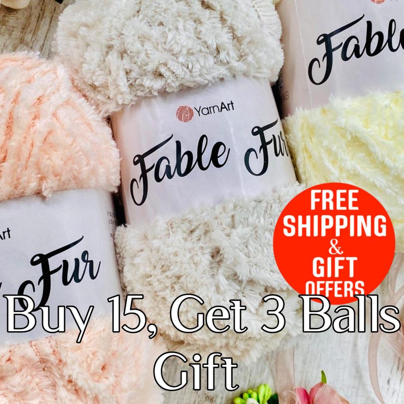 May include: Three skeins of YarnArt Fable Fur yarn in cream, peach, and pale yellow colors. Each skein features a white paper label with the brand name YarnArt and the product name Fable Fur printed in black script text on the front.