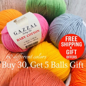 May include: A collection of Gazzal Baby Cotton yarn balls in various vibrant colors including pink, green, yellow, orange, and grey. Each ball features a paper label with the brand name, weight of 1.76 oz, and length of 180 yd printed on it.