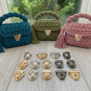 May include: Three small, braided handbags in teal, olive green, and dusty rose, each with a matching tassel and gold-coloured clasp. Below, various metal clasps in gold, silver, and gunmetal are displayed.
