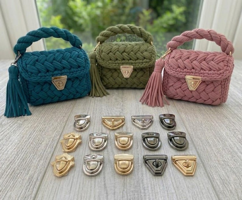May include: Three small, braided handbags in teal, olive green, and dusty rose, each with a matching tassel and gold-coloured clasp. Below, various metal clasps in gold, silver, and gunmetal are displayed.