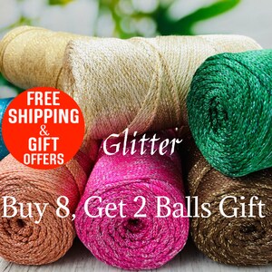 May include: Close-up of several spools of glitter yarn in various colors, including gold, pink, green, and brown. The word "Glitter" is written across the image. The image also contains the text "Buy 8, Get 2 Balls Gift".