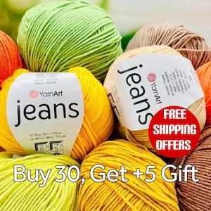 May include: A selection of colourful yarn balls in shades of yellow, orange, green, and brown. The yarn is labelled "YarnArt jeans". The image also includes the text "Buy 30, Get +5 Gift".