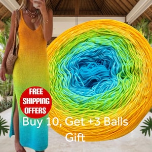 May include: A sleeveless maxi dress featuring a vibrant ombre gradient that transitions from yellow at the top to green and blue at the bottom, paired with a large circular ball of matching multi-colored yarn with text overlay.