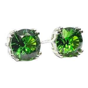 May include: A pair of silver stud earrings with large, round, green gemstones.