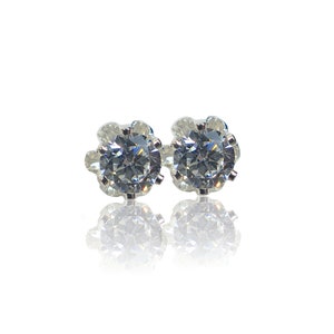 May include: A pair of silver stud earrings with clear round cubic zirconia stones.
