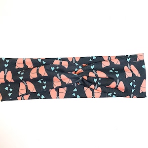 Pode incluir: Uma faixa de cabeça preta com um padrão de pulmões cor-de-rosa e corações azuis.