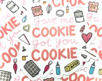 May include: A white sticker with pink and red lettering that says "gave me cookie got you cookie". The sticker is decorated with various baking-themed illustrations, including a heart, a rolling pin, a whisk, a cookie cutter, and a bag of sugar.