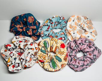 May include: Set of six colorful hair scrunchies with various Thanksgiving-themed prints, including turkeys, gnomes, and food.