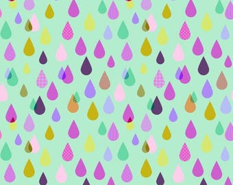 May include: A fabric pattern featuring a repeating design of colorful teardrop shapes in shades of pink, purple, yellow, and green, set against a light green background. The pattern includes a ruler along the bottom edge, with measurements up to 12 inches.