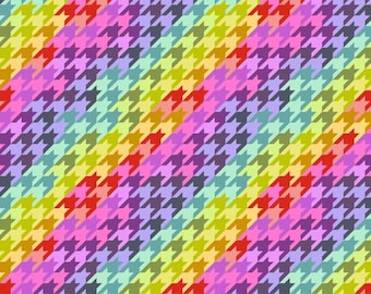 May include: A vibrant fabric featuring a colorful houndstooth pattern in diagonal stripes. The design incorporates a spectrum of colors, including red, yellow, purple, and blue. The fabric is marked with a ruler in inches along the bottom edge.