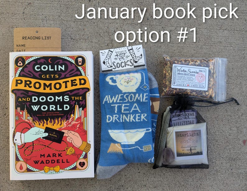 May include: A gift set including a book, blue socks with "Awesome Tea Drinker" text, tea, and a small bag with amethyst and starlight items. The book is titled "Colin Gets Promoted and Dooms the World." A reading list is also included.