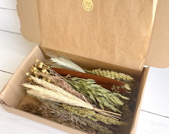 May include: A cardboard box filled with dried grasses and reeds. The box is open and the dried flowers are visible. The box has a sticker that says "handmade with love".