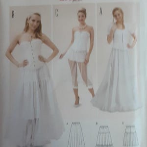 May include: A Burda Style sewing pattern, number 6739, featuring three white dress designs. The pattern includes illustrations of the dress styles and the text "Super Easy". The text "All patterns with seam and hem allowances" is also visible.