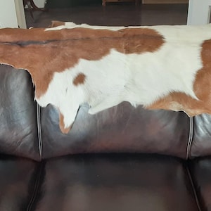 May include: A rustic wooden sign with the text "Welcome" in a handwritten style. The sign is painted white with a distressed finish, and a small, decorative heart is attached to the bottom. The background is a blurred image of a wooden surface.