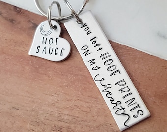 May include: Silver keychain with a heart charm that says "Hot Sauce" and a rectangular charm that says "You left hoof prints on my heart".