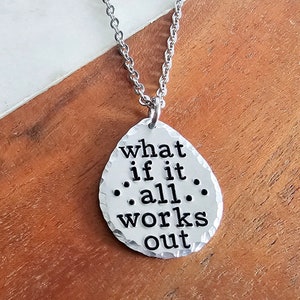 May include: Silver necklace with a hammered metal pendant that reads "what if it .all. works out".