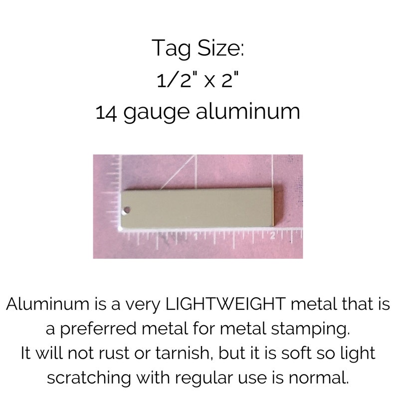K&ouml;nnte beinhalten: Nahaufnahme einer 1,27 cm x 5,08 cm gro&szlig;en Aluminium-Etikette in St&auml;rke 14. Die Etikette ist hellgrau und hat oben ein Loch. Die Etikette liegt auf einer rosa Oberfl&auml;che mit einem Lineal dahinter.