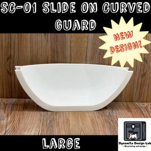 May include: A white SC-01 slide on curved guard with a large, semi-circular shape. The image includes the text SC-01 SLIDE ON CURVED GUARD, LARGE, and a yellow starburst graphic with the text NEW DESIGN. A small logo with a cat icon is present.