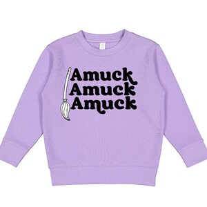 May include: A lavender sweatshirt with a black graphic of a broom and the text "Amuck Amuck Amuck".