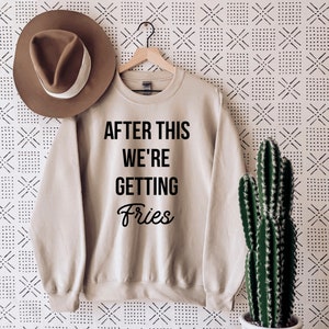 May include: Beige sweatshirt with black text that reads "After this we're getting fries".