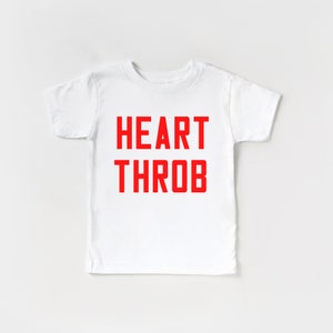May include: White t-shirt with the words "HEART THROB" printed in red.