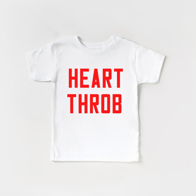 May include: White t-shirt with the words "HEART THROB" printed in red.