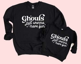 May include: Two black crewneck sweatshirts with white text. The larger sweatshirt says "Ghouls just wanna have fun". The smaller sweatshirt says the same thing in a smaller font.