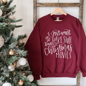 May include: Burgundy sweatshirt with white text that reads "I just want to bake stuff & watch Christmas movies".