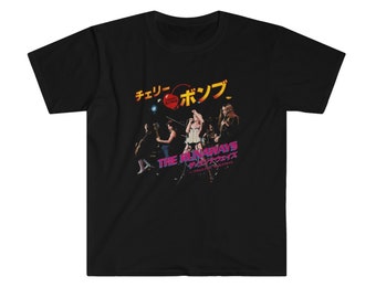 May include: Black t-shirt featuring a graphic of the band The Runaways. The design includes Japanese text and the words "Cherry Bomb" in a heart-shaped design. The band members are depicted in a concert setting.