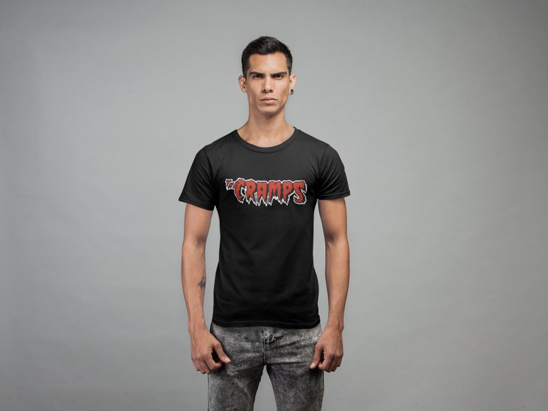 May include: A black t-shirt with a red "The Cramps" logo printed on the front.