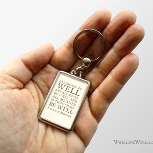 May include: A silver keychain with a rectangular charm that reads "ALL SHALL BE WELL AND ALL SHALL BE WELL AND ALL MANNER OF THING SHALL BE WELL JULIAN OF NORWICH".